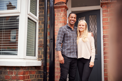 happy couple standing outside home welcoming atmosphere